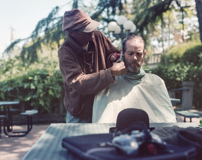 Dream Weaver gives his brother, Innate Thought, a haircut—a service Dream provides for many anchor-outs.